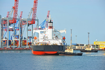 Fototapeta premium Tugboat assisting bulk cargo ship