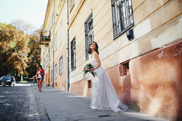 young and happy girl with a bouquet walking down the street