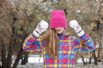 Funny girl playing with snowballs