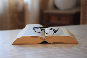 Ein aufgeschlagenes Buch mit Lesebrille