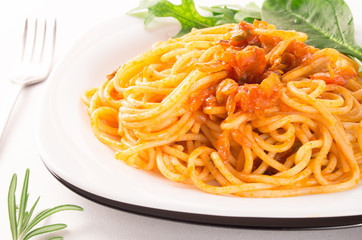 Spaghetti with vegetable sauce and herbs close-up