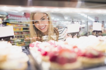 Portrait of woman looking at desserts shelf