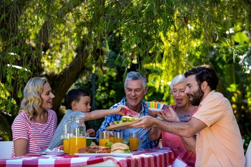 Happy family enjoying while having meal in yard 