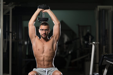 Obraz na płótnie Canvas Geek Man With Dumbbell Exercising Triceps