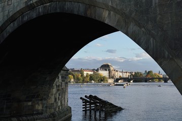 Blick unter die Karlsbrücke hindurch auf Prag mit dem Nationaltheater in der Mitte des Bildes