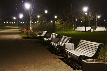 White benches in the park night time.