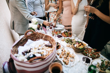 friends drink alcohol and eat snacks and talk at the celebration of the wedding. communication concept