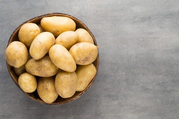 New potato on the bowl, gray background.