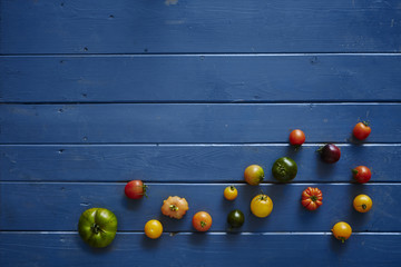 Fototapeta na wymiar variety of tomatoes on blue wooden table