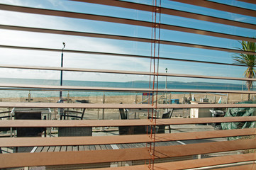 Through the window blinds.