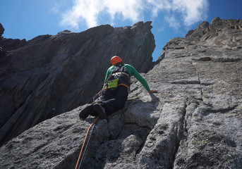 young man climbing rock in Alps