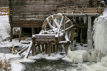 Waterwheel of old watermill in Krasnikovo, Kursk region. Winter, watermill is fr