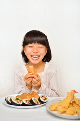 お寿司を美味しそうに食べる女の子