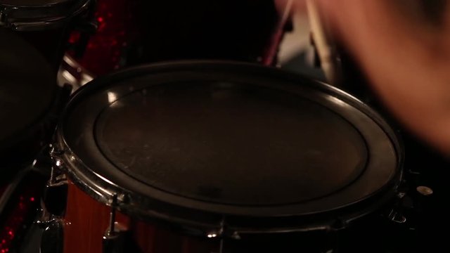 drummer playing on drums in a dark room