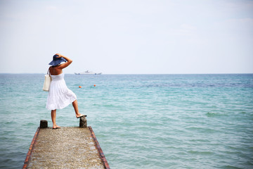 Fototapeta na wymiar Woman in white summer dress enjoying beach and summer sunny day