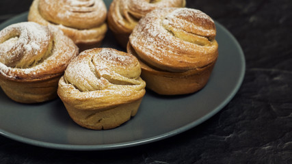 Homemade pastries cruffins, muffin with sugar powder, on dark background, selective focuse close up