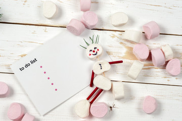 Christmas card with fun marshmallow snowman in green cup, tree