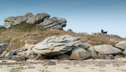 Fototapeta na wymiar ein Mann und sein Hund machen Rast an Felsen, Keremma, Bretagne, Frankreich