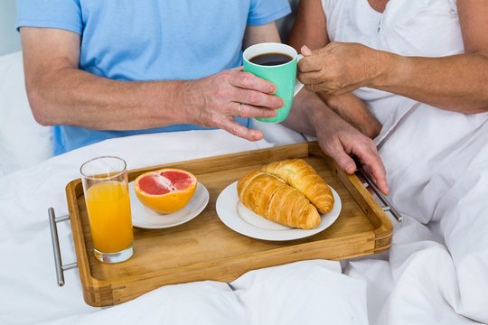 Midsection of senior couple with breakfast