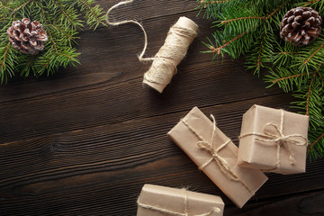 Christmas composition on wooden background with tree, pine cones and cardboard boxes