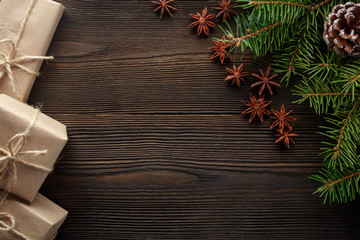 Christmas composition on wooden background with tree, pine cones, star anise and cardboard boxes