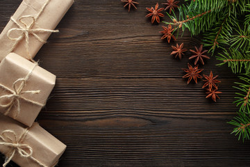 Christmas composition on wooden background with tree, pine cones, star anise and cardboard boxes