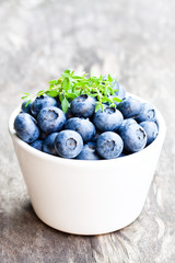 Ripe  blueberries in a bowl with thyme leaves