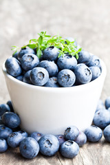 Ripe  blueberries in a bowl with thyme leaves