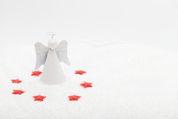 Angel surroundeed by red plastic stars in fake snow