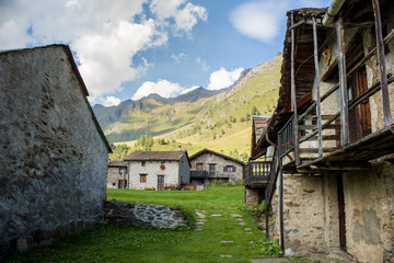 Fototapeta na wymiar Stone chalets in a tiny mountaing village. Case di Viso - Ponte