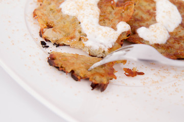 Potato Pancakes with cream and brown sugar eaten with a fork
