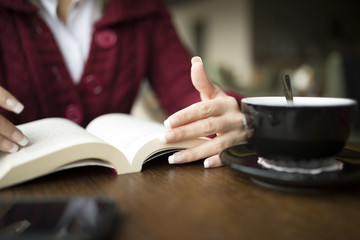 Fototapeta na wymiar Woman Reading Book At Cafe