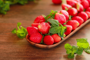strawberries on a wooden plate on a wooden background