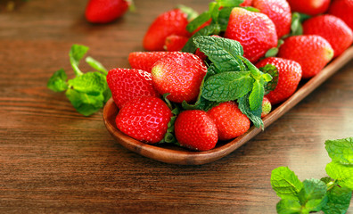 strawberries on a wooden plate on a wooden background