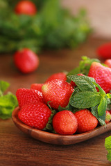 strawberries on a wooden plate on a wooden background