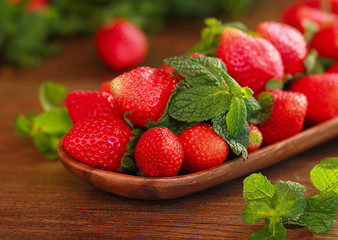 strawberries on a wooden plate on a wooden background