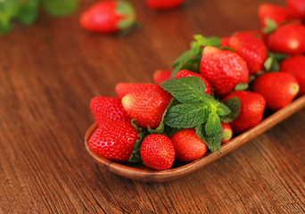 strawberries on a wooden plate on a wooden background