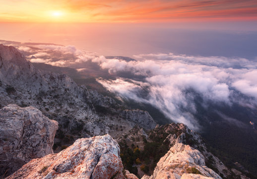 Fototapeta Mountain landscape at sunset. Amazing view from the mountain peak on rocks, low clouds, blue sky and sea in the evening. Colorful nature background. Adventure. Travel in Crimea. Beautiful scenery