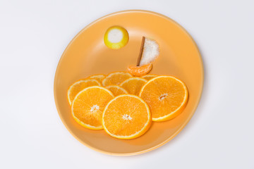Decor of sweet and citrus on orange plate flat lay.