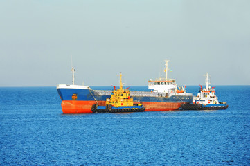 Tugboat assisting bulk cargo ship