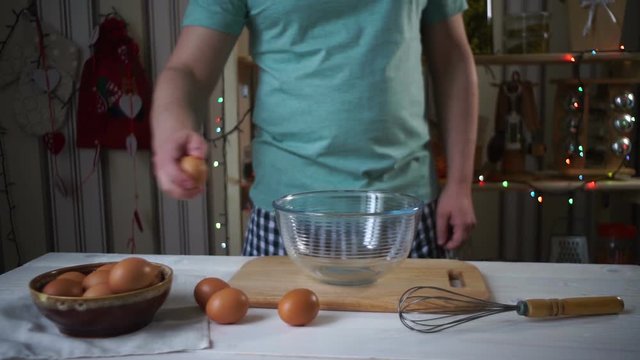 Chef break egg. Breaking egg into glass bowl. Chef cooking food. Baking ingredients. Man breaking egg in slow motion. Preparing ingredients for baking. Male hands breaking fresh egg