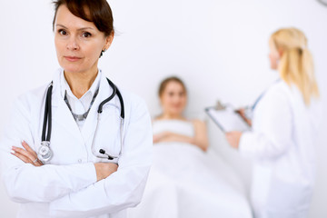 Fototapeta premium Female doctor smiling on the background with patient and his doctor