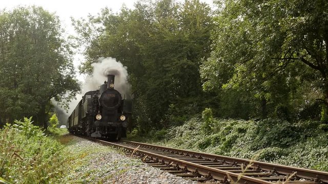 steam engine train locomotive driving on railroad tracks. nostalgic transportation background.