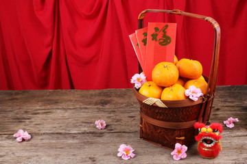 Basket of mandarin oranges with Chinese new year red packets