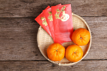 Basket of mandarin oranges with Chinese new year red packets