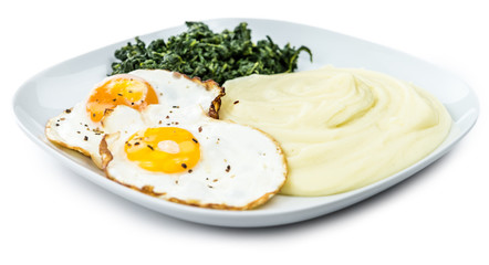 Mashed Potatoes with fried eggs and spinach isolated on white