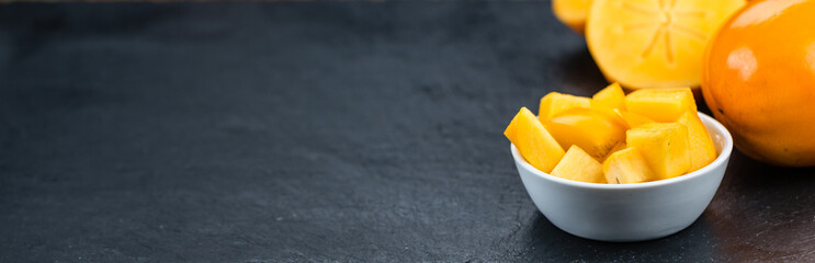 Kaki fruits on a slate slab (selective focus)