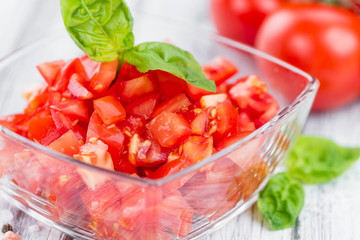 Tomatoes (diced) on wooden background (selective focus)