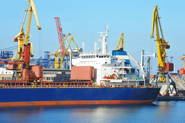 Obraz premium Bulk cargo ship under port crane