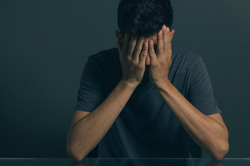 Sad man sitting in dark room. Depression and anxiety disorder concept